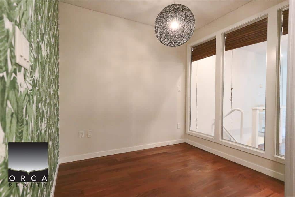 Bright cozy interior room with large windows and hardwood flooring, ideal for modern living and real estate in Vancouver, BC.