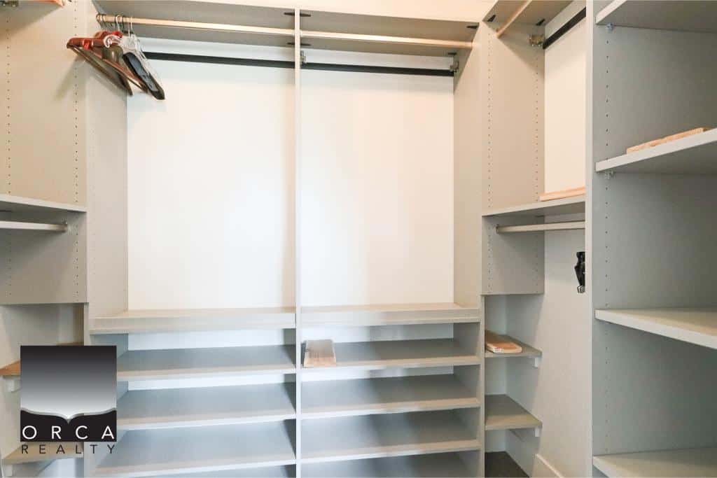 Spacious walk-in closet with built-in shelves and hanging space, ideal for organizing your clothing and accessories in your home or condo.