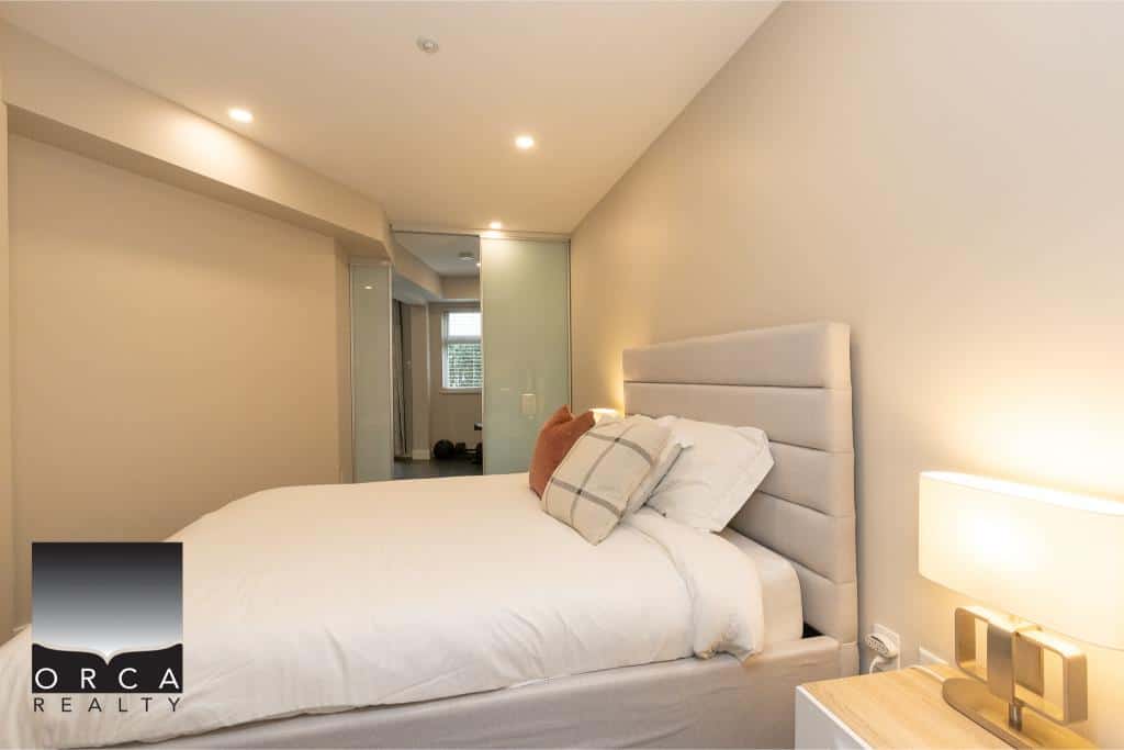 Modern bedroom in Toronto condo with minimalist decor, soft lighting, and comfortable bedding, highlighting Orca Realty’s luxurious property listings and real estate services in Vancouver.