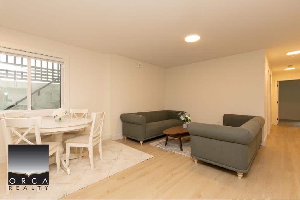 Bright and spacious living room with modern furniture, hardwood floors, and ample natural light, featuring a cozy seating area perfect for relaxing or entertaining guests at Orca Realty Inc.