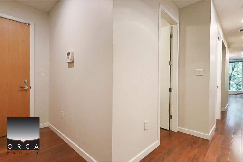 Bright modern hallway in a Vancouver real estate listing at Orca Realty Inc., showcasing sleek interior design, hardwood flooring, and spacious entryway for potential homebuyers.