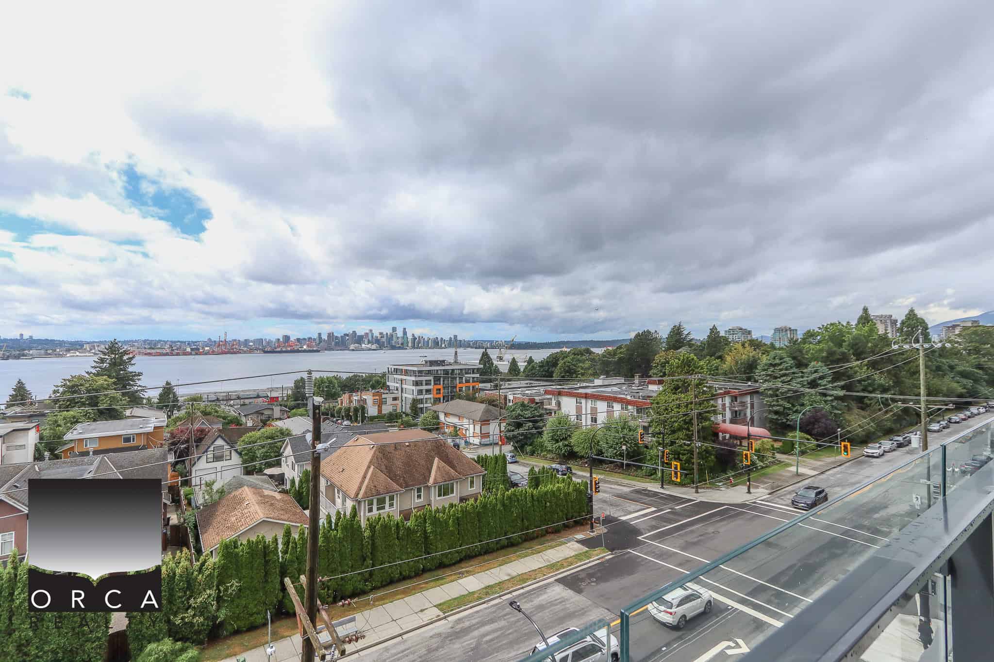 Panoramic view of Vancouver skyline and waterfront from a balcony, showcasing residential neighbourhoods, lush greenery, and urban infrastructure in a vibrant real estate market.