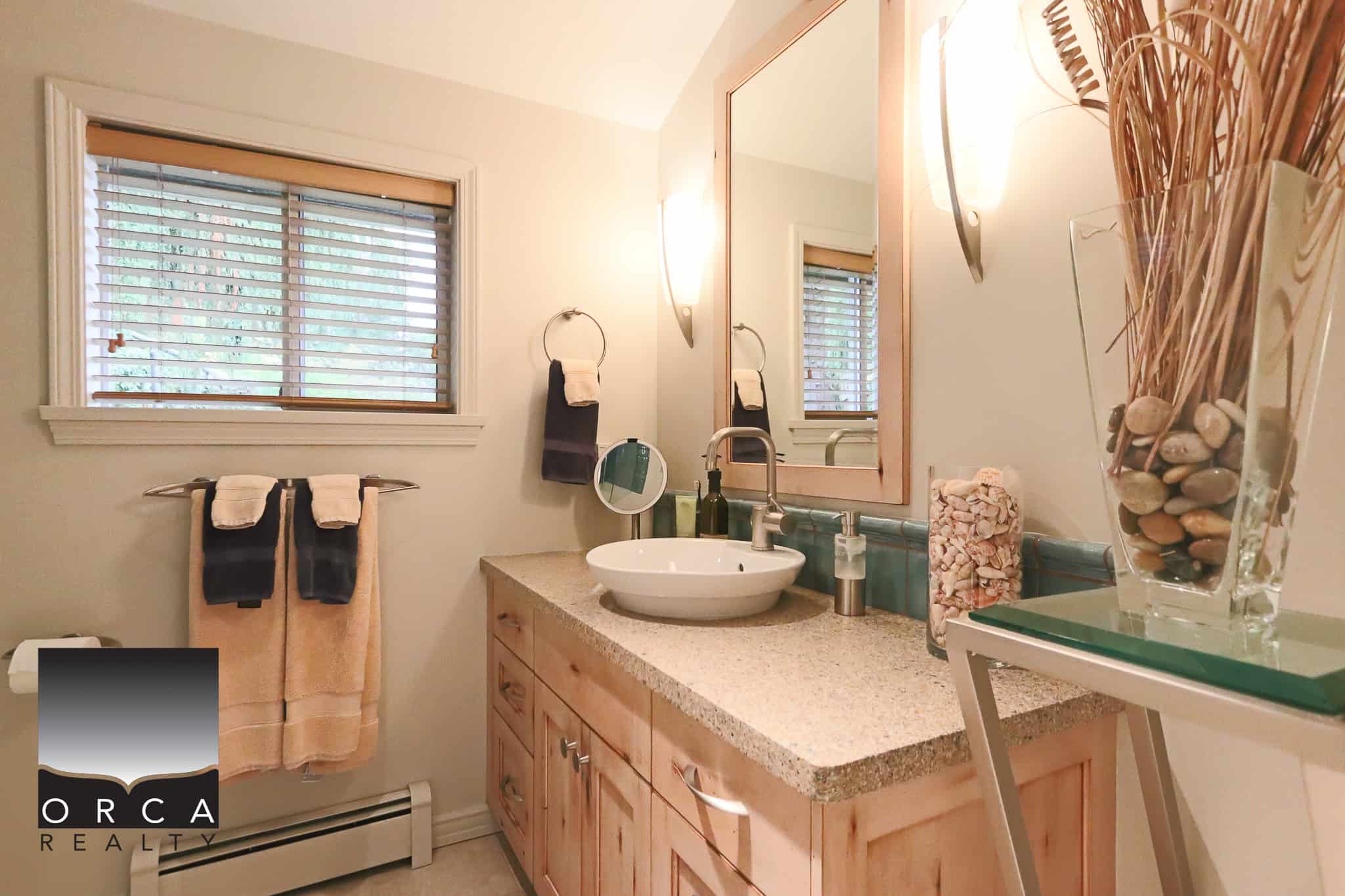 Bright bathroom with natural light, wooden vanity, vessel sink, and modern fixtures, perfect for modern home living in Orca Realty Inc. property, Vancouver, BC.