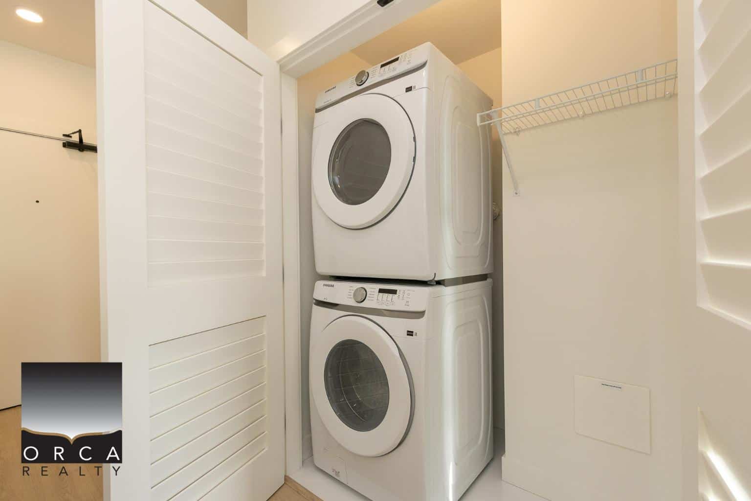 Clean laundry area with stacked washer and dryer, perfect for modern homes with efficient space utilization.