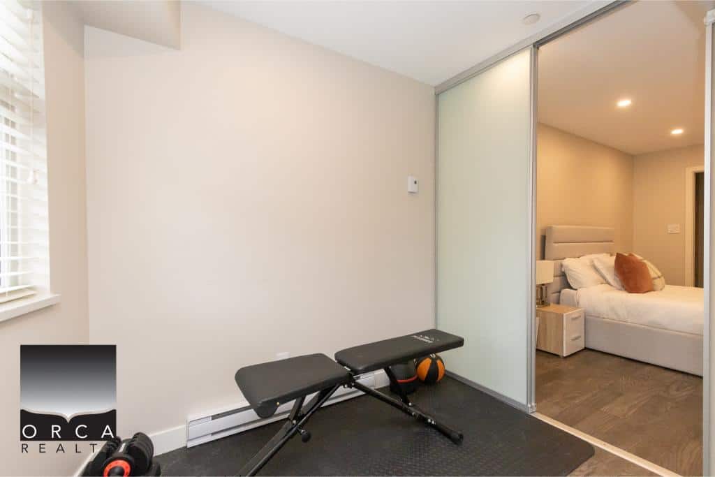 Modern home gym area with workout bench, weights, and exercise ball in a bright, minimalist space with neutral decor in a Vancouver-area property.