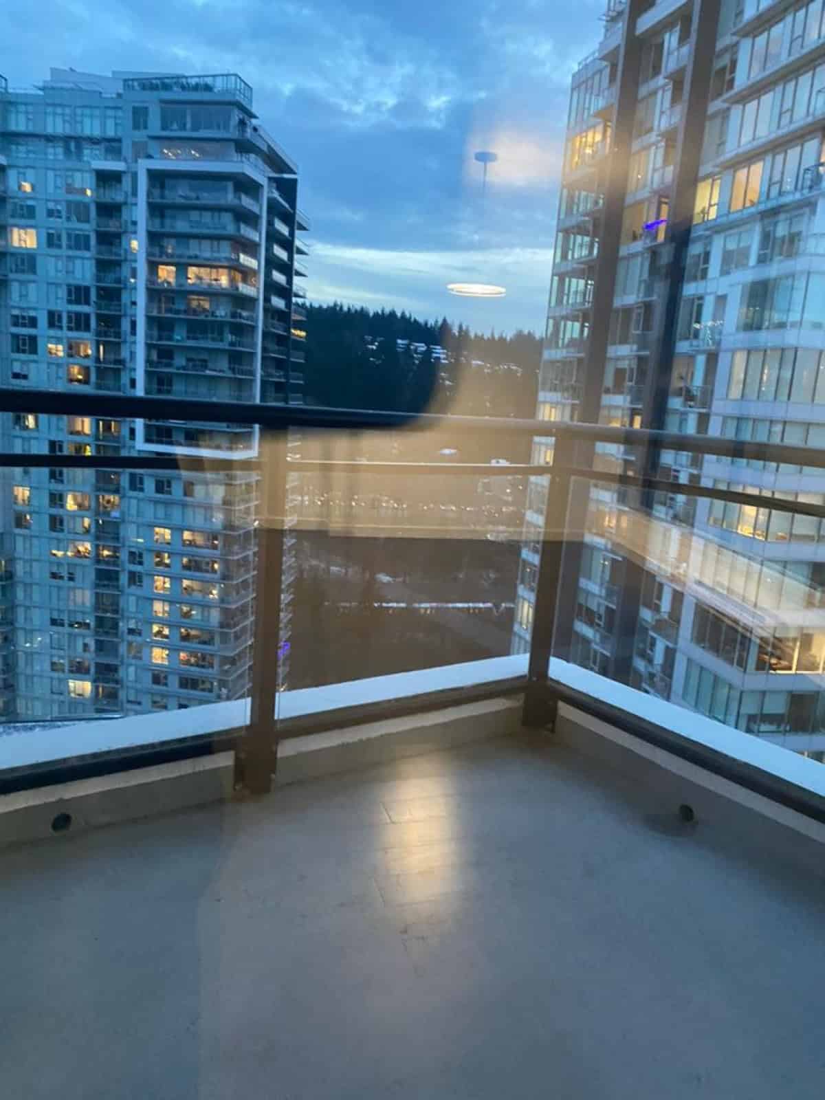 Modern high-rise apartment balcony showcasing city skyline views and nearby residential buildings in Vancouver, BC. Perfect property listing image for Orca Realty Inc., highlighting urban living amenities.