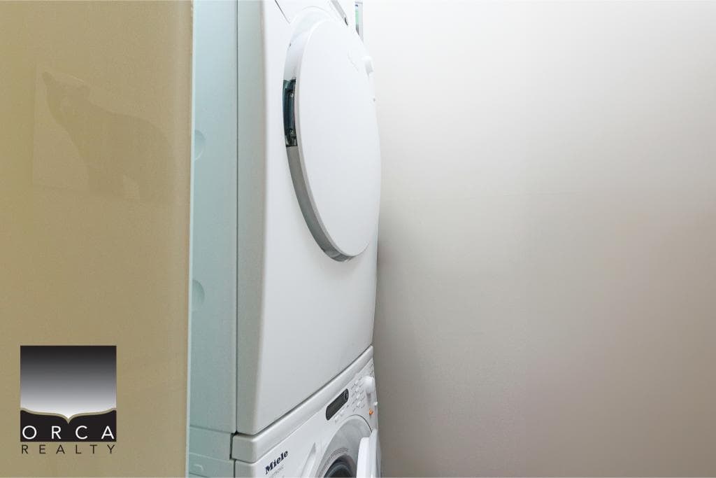 Clean stacked washer and dryer in a laundry room, showcasing modern appliances.