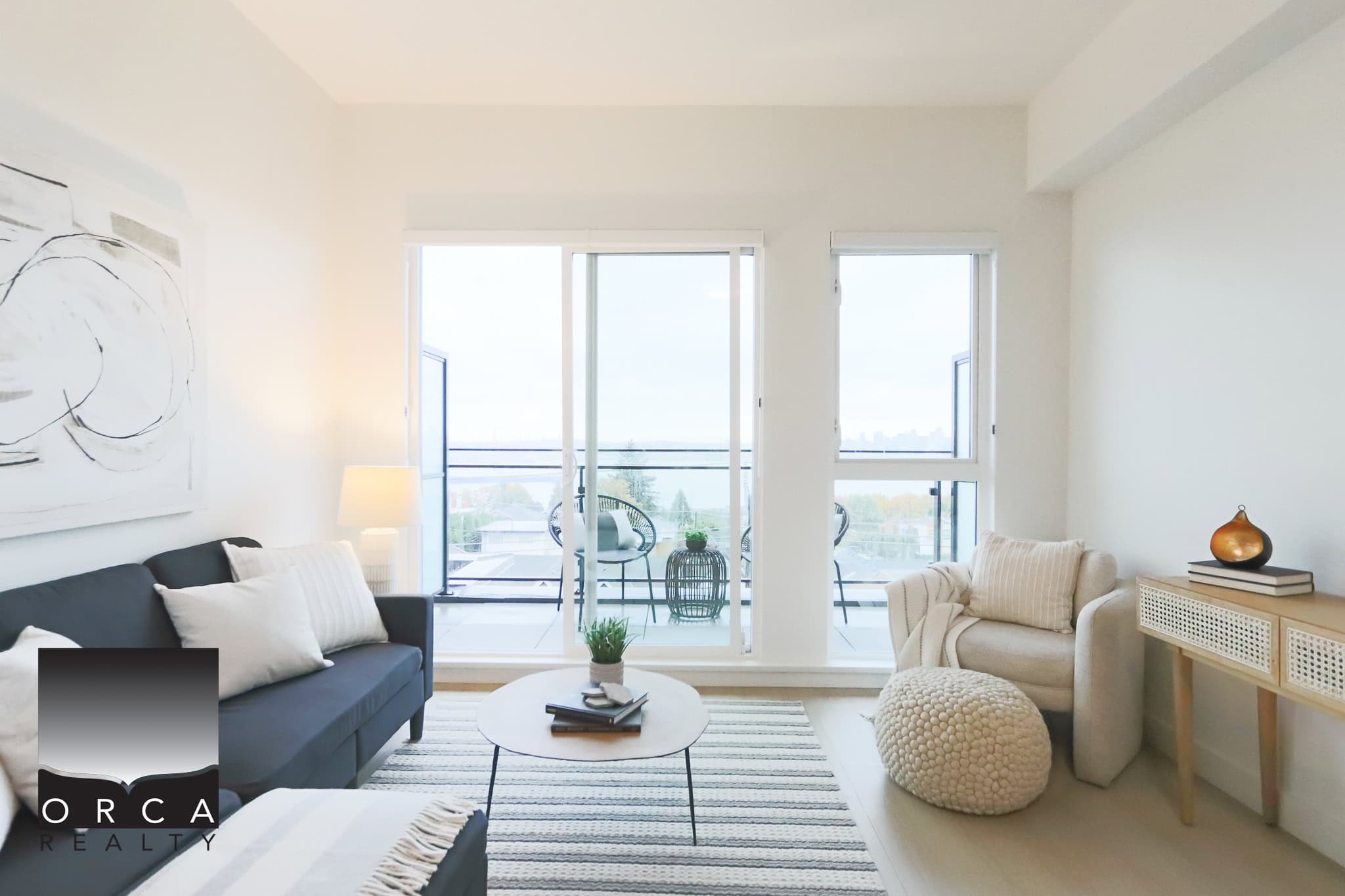 Spacious modern living room with large windows, balcony access, minimalist decor, neutral color palette, and stylish furniture, showcasing downtown Vancouver views.