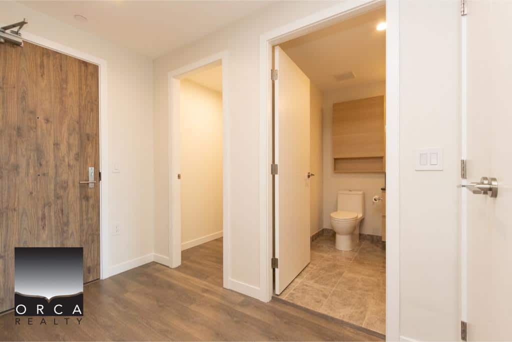 Modern apartment interior with a clean, minimalist design, featuring a private bathroom and neutral tones, ideal for comfortable living in Vancouver's real estate market.