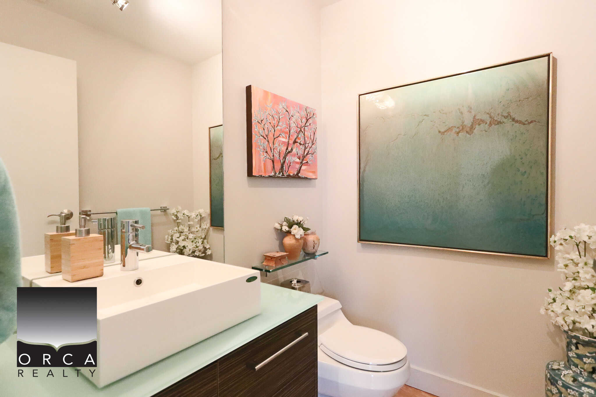 Modern bathroom interior with vessel sink, contemporary artwork, and elegant decor at Orca Realty Inc., showcasing luxury Vancouver Island real estate and home listings.