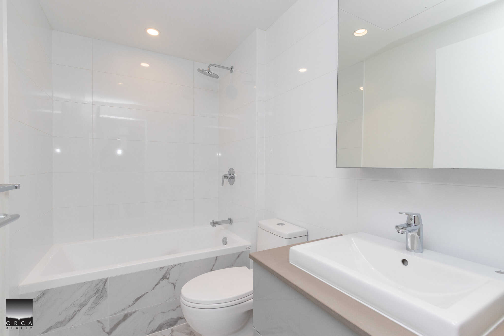 Modern white bathroom with a bathtub, walk-in shower, and sleek sink featuring minimalist design and contemporary fixtures. Perfect for upscale Vancouver Island real estate listings.