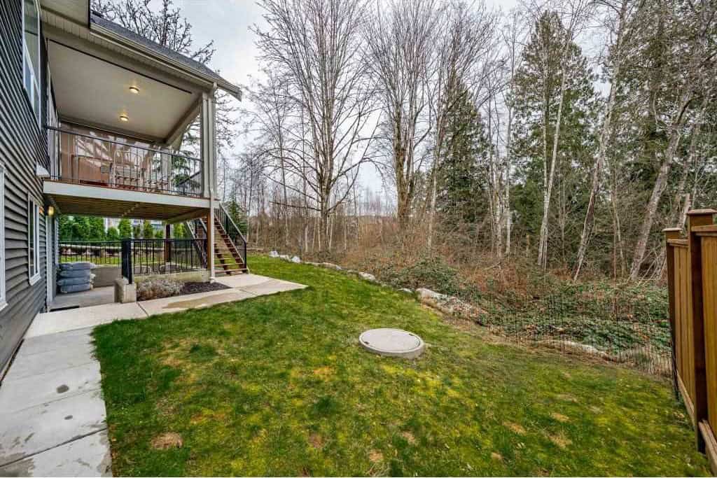 Spacious backyard with multi-level decking and lush lawn, ideal for outdoor entertaining in Kelowna, BC. Perfect for families and garden enthusiasts seeking a serene outdoor space.