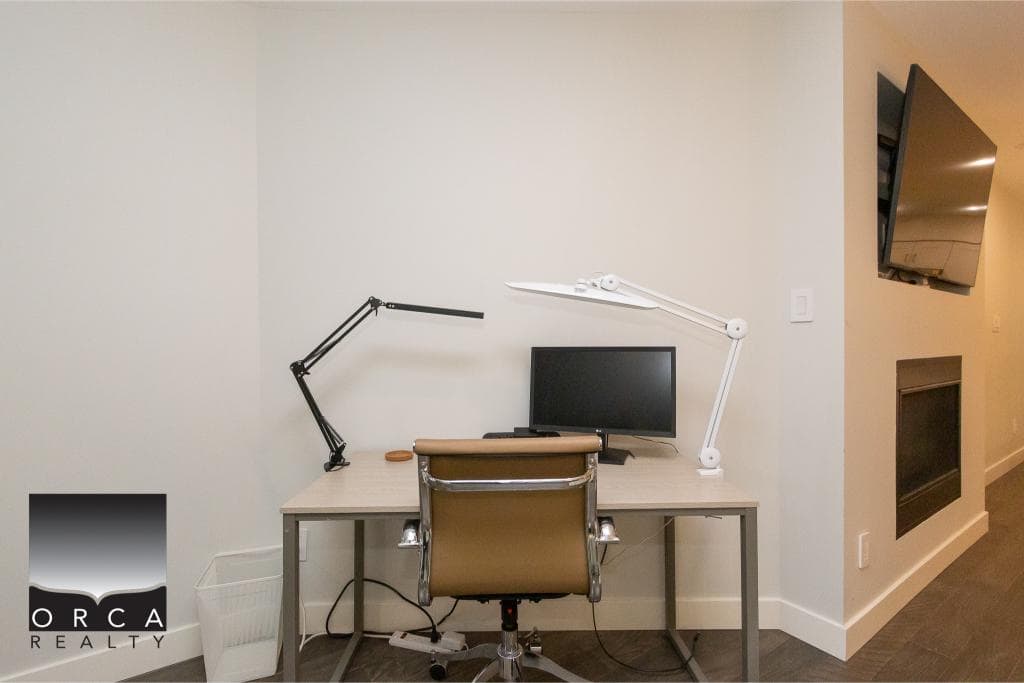 Modern home office space with a sleek desk, ergonomic chair, dual adjustable desk lamps, and a computer monitor, ideal for remote work or study. Perfect for buyers seeking a functional, stylish workspace.