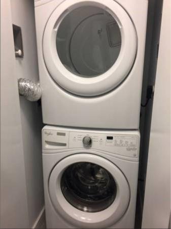 Stacked washer and dryer units in a laundry closet, modern home appliances for convenient in-unit laundry.