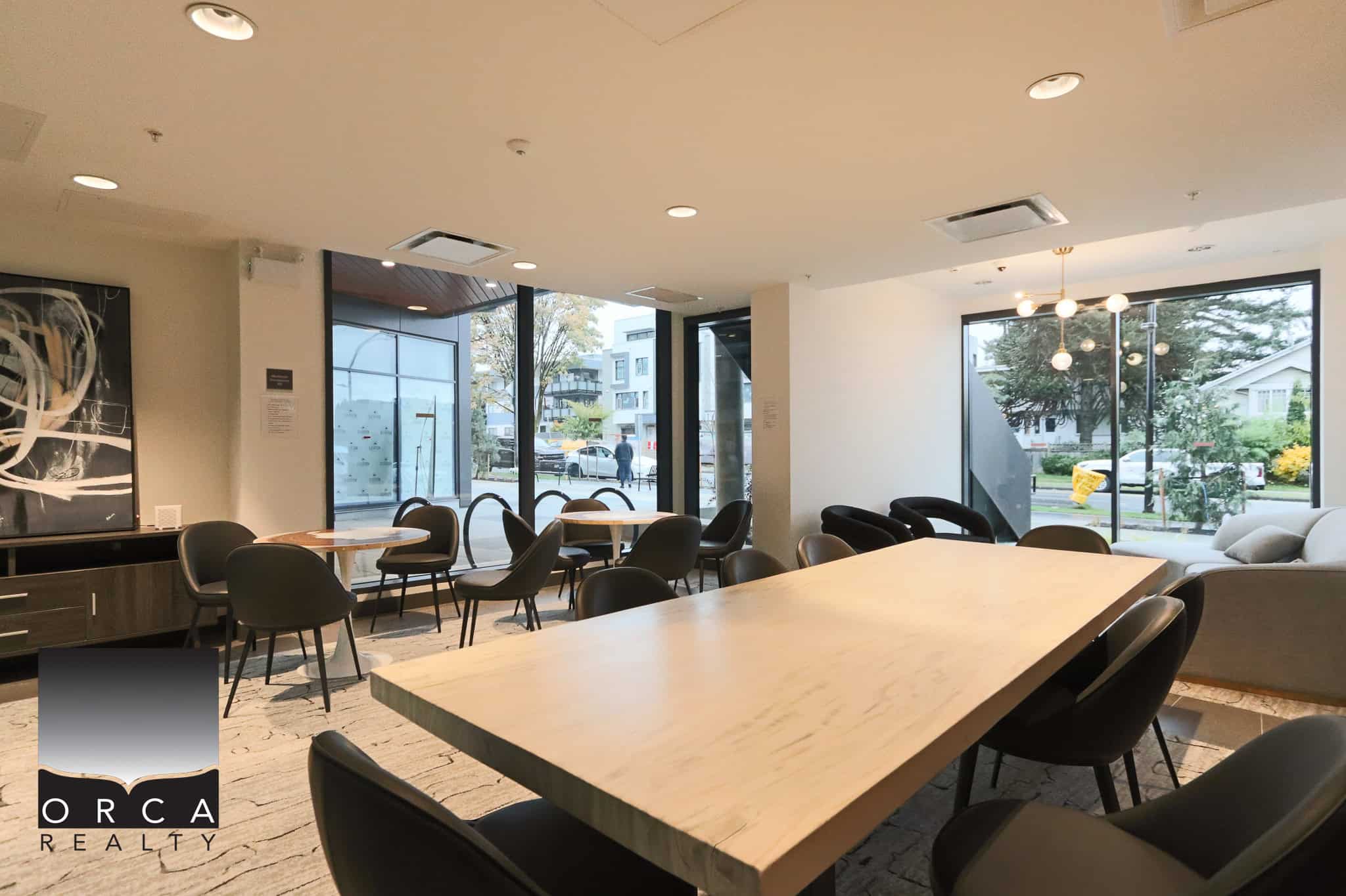 Modern condo lobby with ample seating and large windows in Vancouver, BC, showcasing nightlife and urban lifestyle amenities, ideal for real estate listings and property marketing.