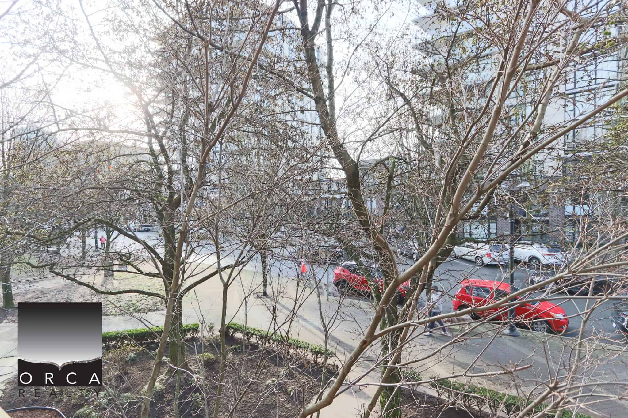 Modern condo view with trees and parking in North Vancouver.