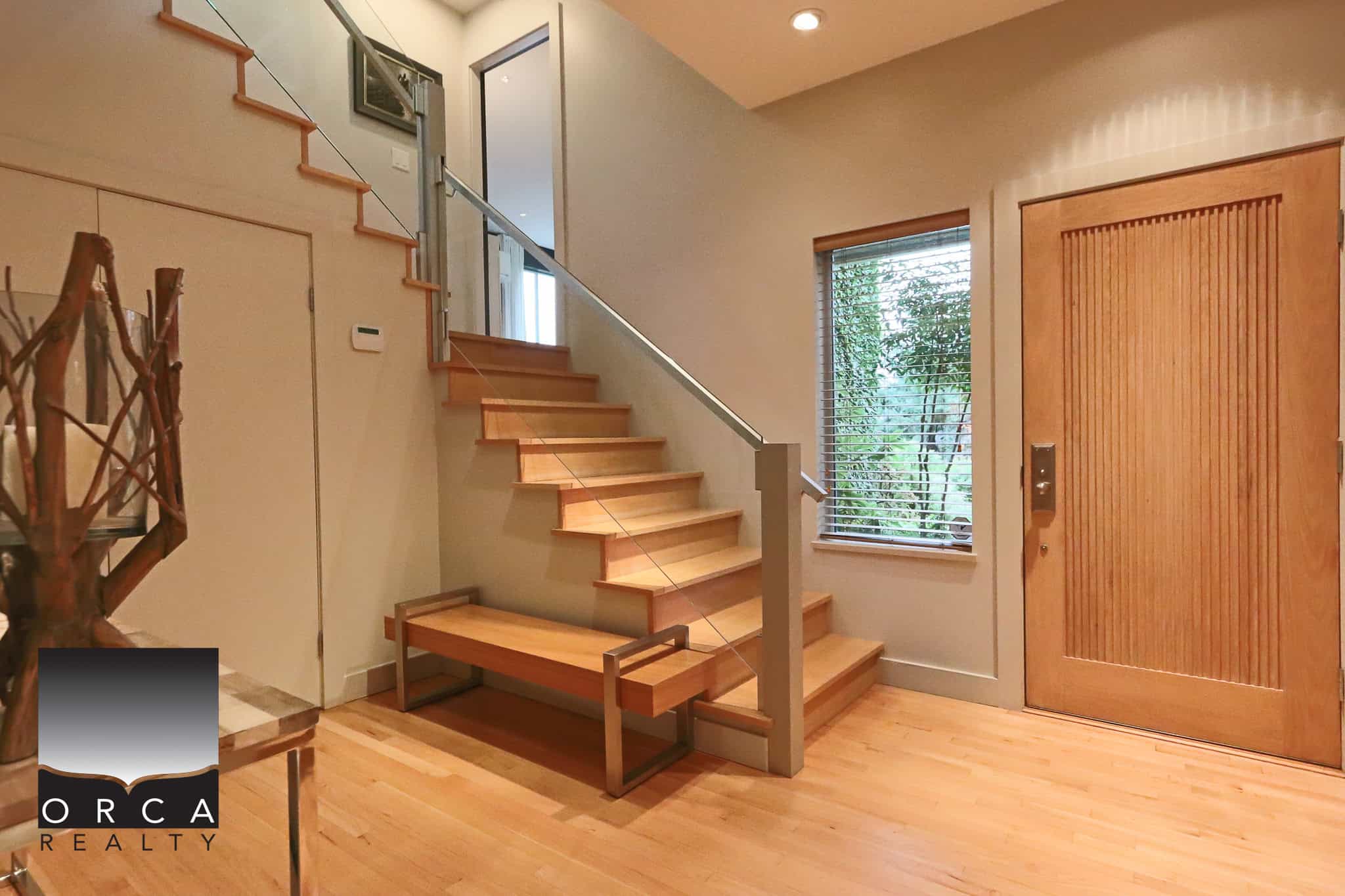 Modern wooden staircase interior with natural light, hardwood flooring, and stylish decor, perfect for showcasing Vancouver Island homes and real estate opportunities.