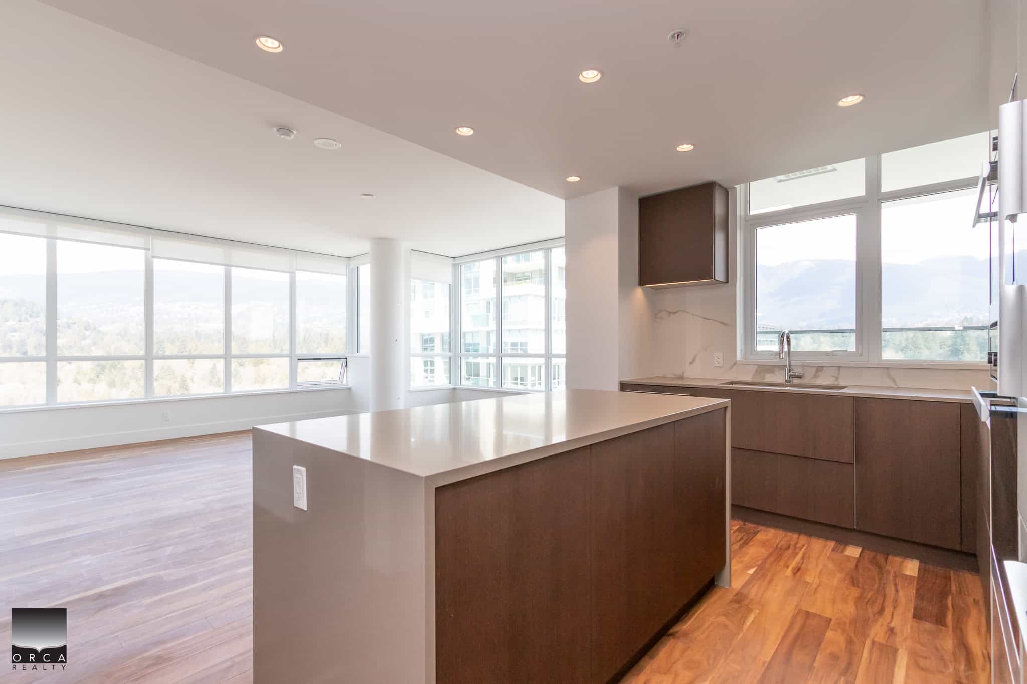 Spacious modern condo kitchen featuring large windows, sleek cabinetry, and contemporary finishes, perfect for urban living and real estate investment in BC.