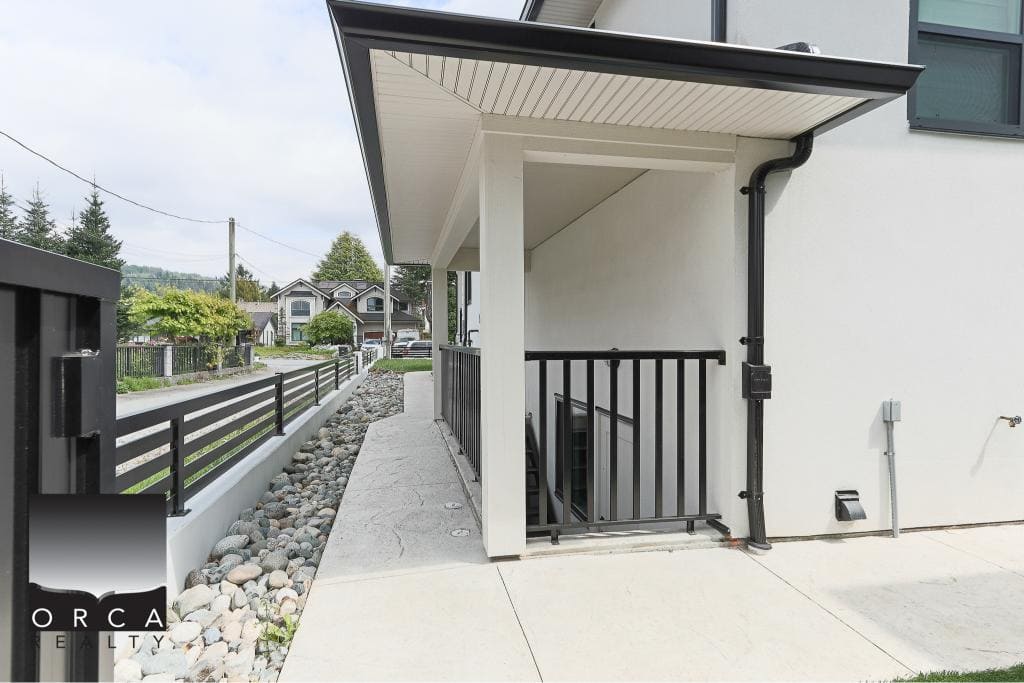 Modern condo entrance with stairs and black railing, Vancouver real estate, contemporary architecture, outdoor space, secure entry, residential property, Orca Realty Inc.