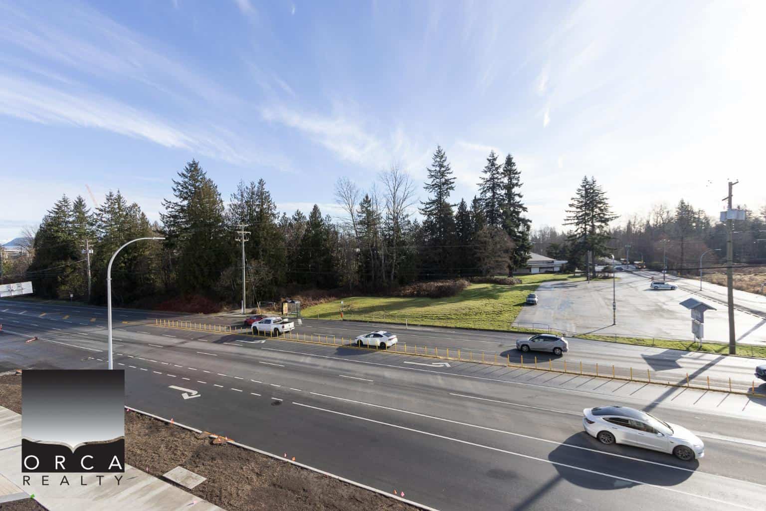 Highway view of commercial land and wooded area for sale in Victoria BC, prime location for real estate investments by Orca Realty Inc.
