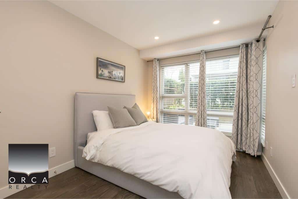 Bright modern bedroom with large windows, natural light, cozy bed, contemporary decor, and stylish curtains, perfect for Vancouver real estate homes.