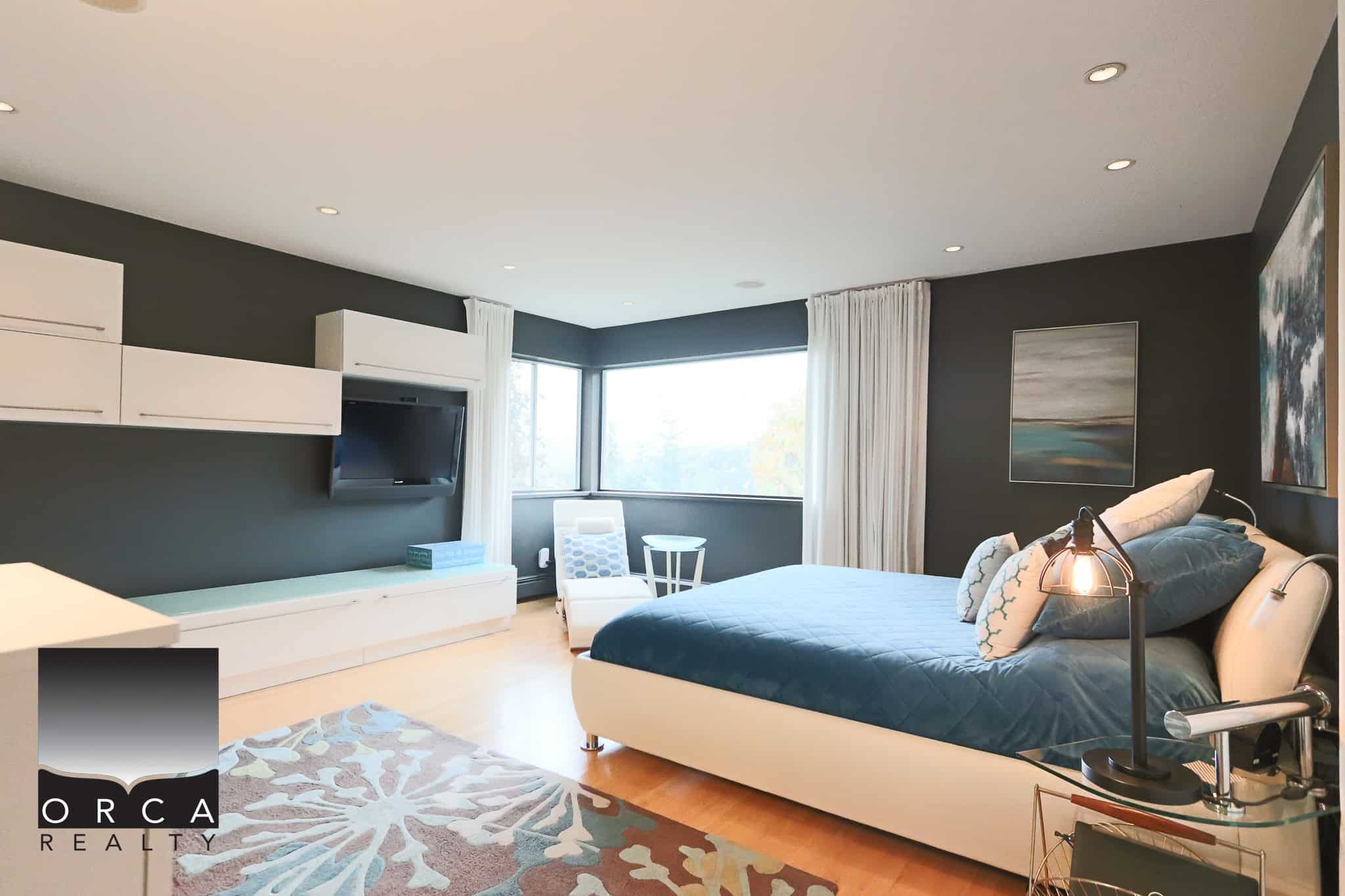 Luxurious modern bedroom with large windows, stylish decor, and contemporary furniture, perfect for Vancouver real estate buyers seeking upscale residential properties.