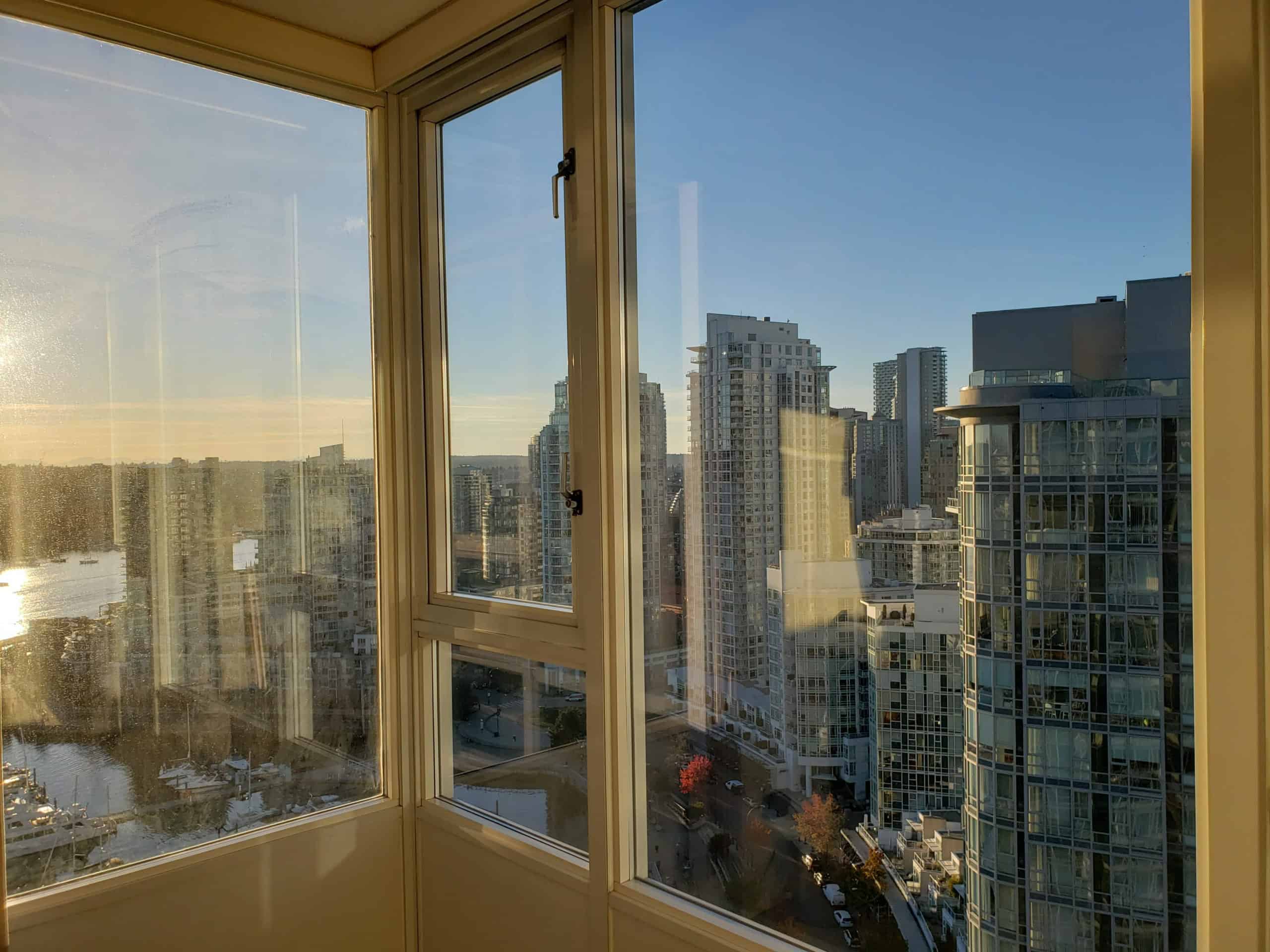 Stunning city skyline view from a high-rise condo in Vancouver, showcasing modern architecture, scenic water reflections, and vibrant neighbourhoods, perfect for luxury real estate investment in BC.