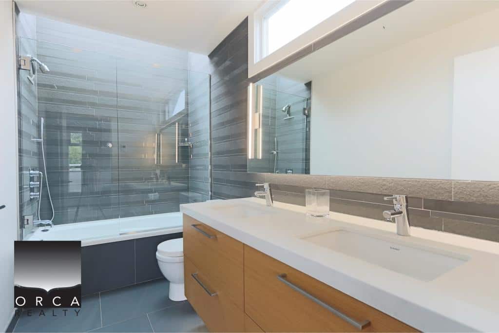 Modern bathroom with glass-enclosed shower, sleek vanity, and contemporary design showcasing high-end Vancouver real estate.