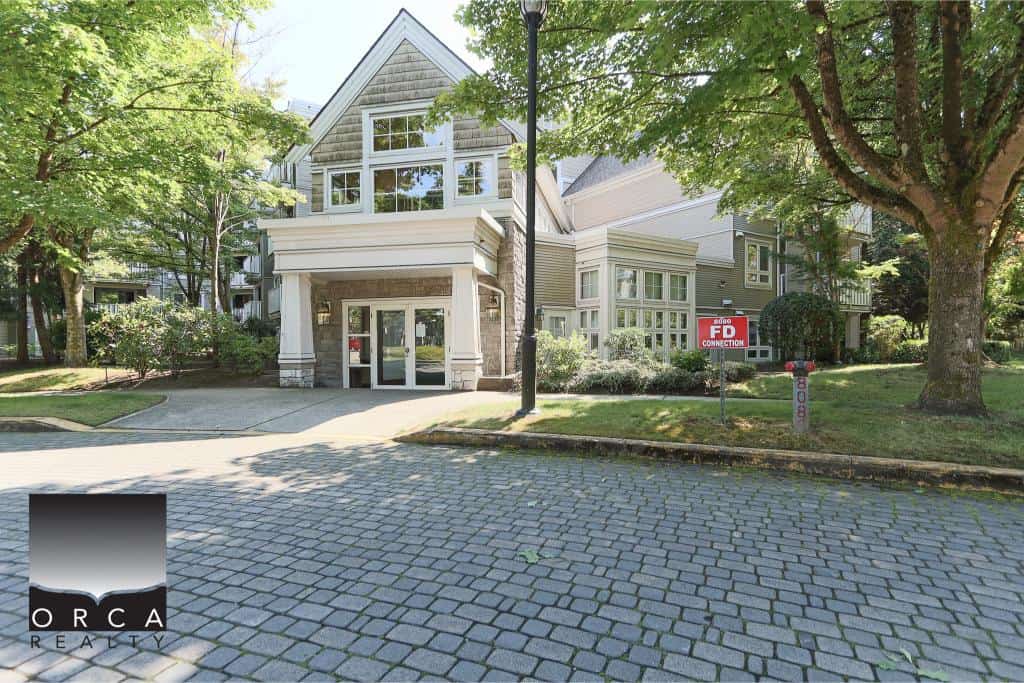 Modern multi-family residential building with well-maintained landscaping and a cobblestone driveway in a desirable neighbourhood.