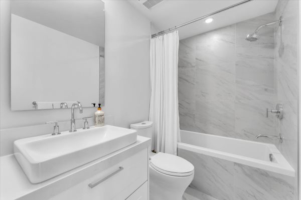 Contemporary Vancouver bathroom featuring a stylish white vanity, modern fixtures, and a spacious shower with marble accents. Perfect for showcasing upscale property features.