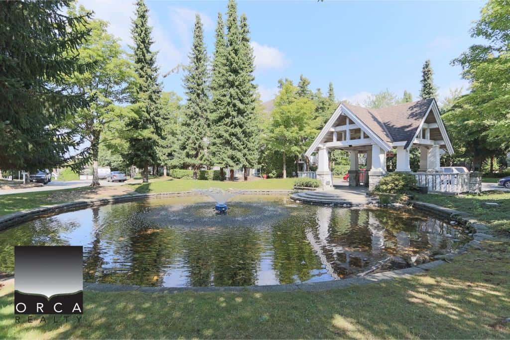 Serene park with pond, fountain, and gazebo in a lush, green setting, showcasing Orca Realty Inc.'s excellent property management and real estate services in British Columbia.
