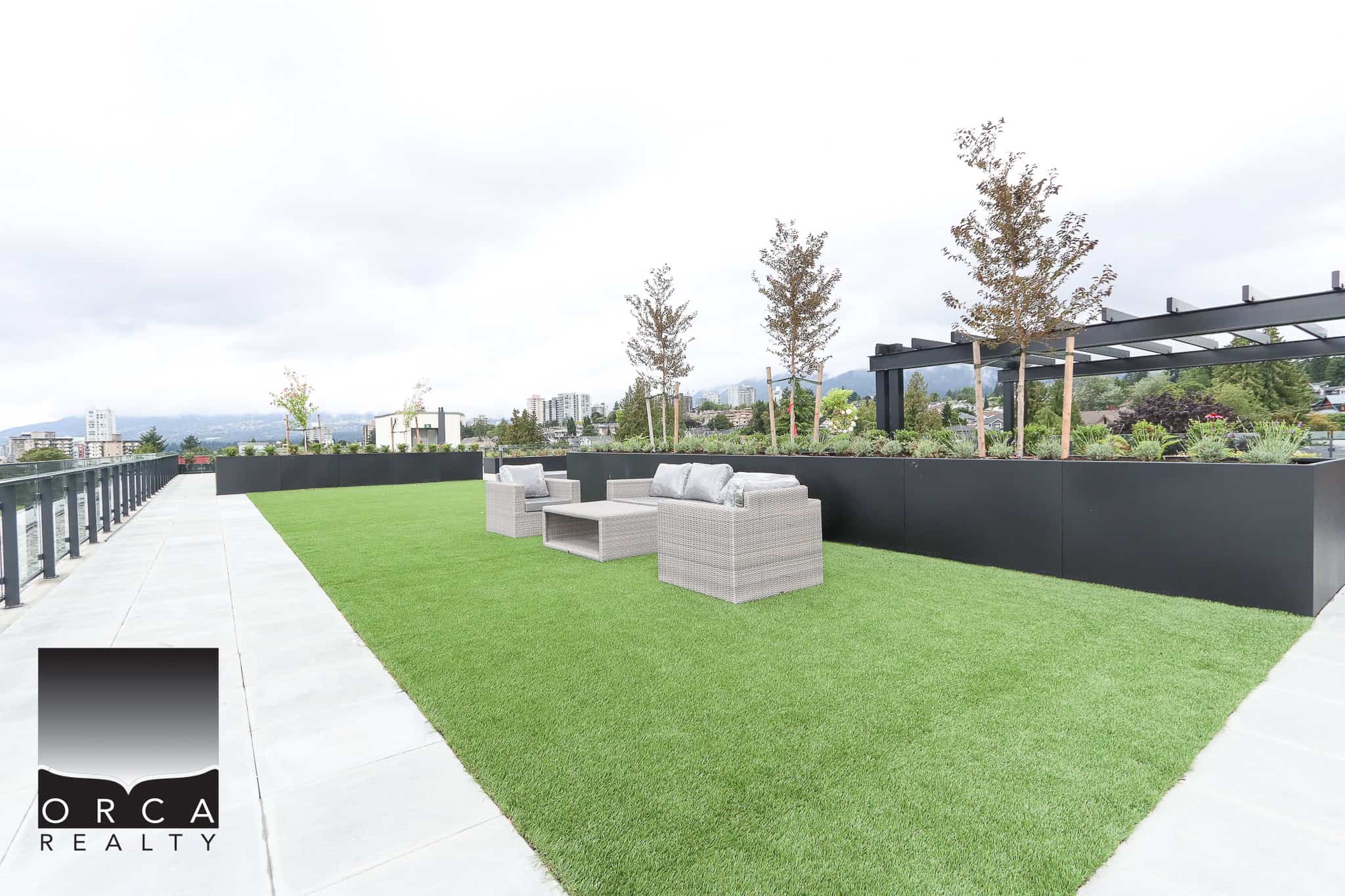 Modern rooftop terrace with lush artificial grass, stylish outdoor seating, and city views, perfect for luxury condo living in Vancouver.