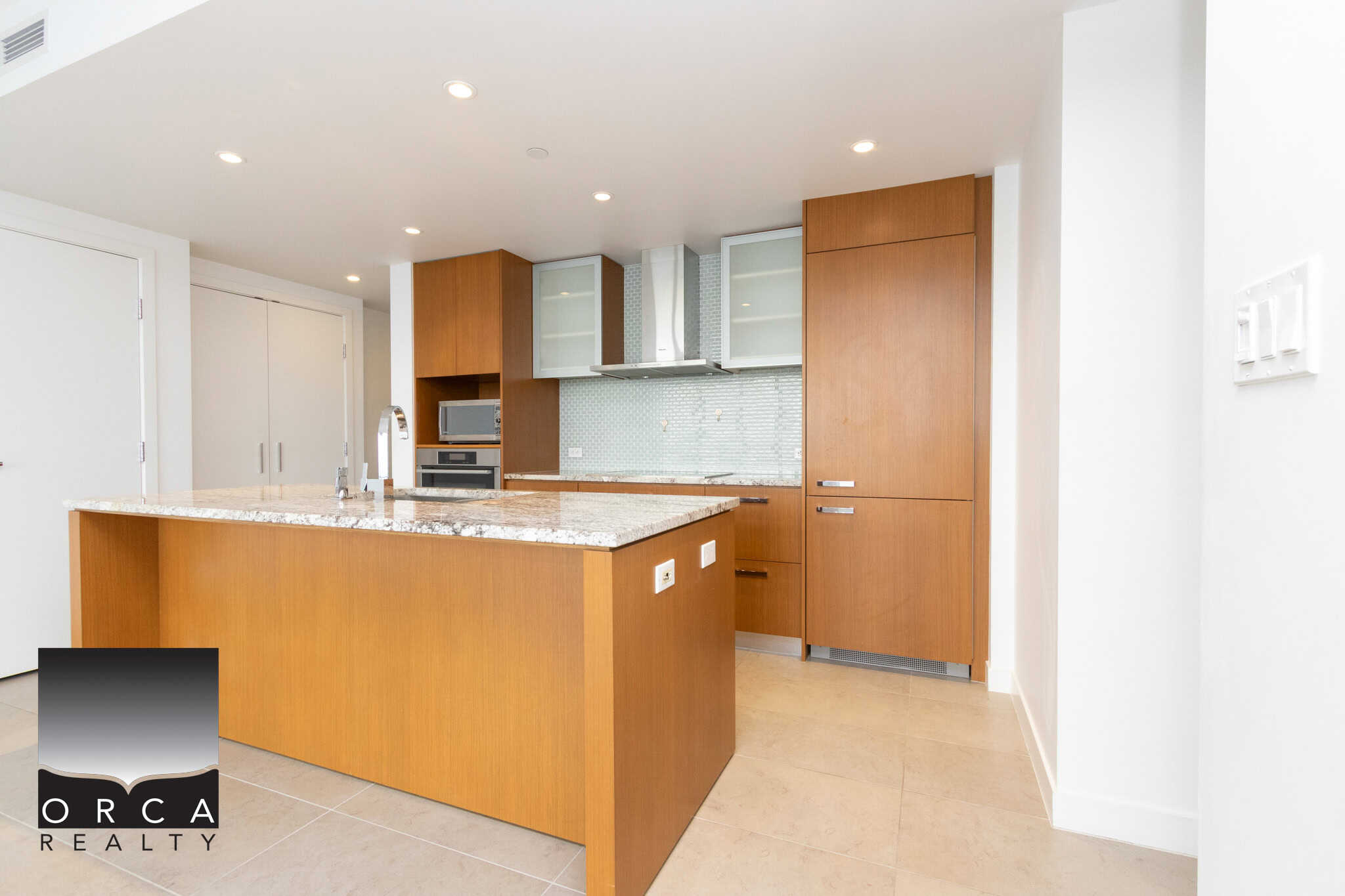 Modern kitchen with wooden cabinets, granite countertops, stainless steel appliances, and a tiled backsplash, perfect for luxury real estate in Canada.