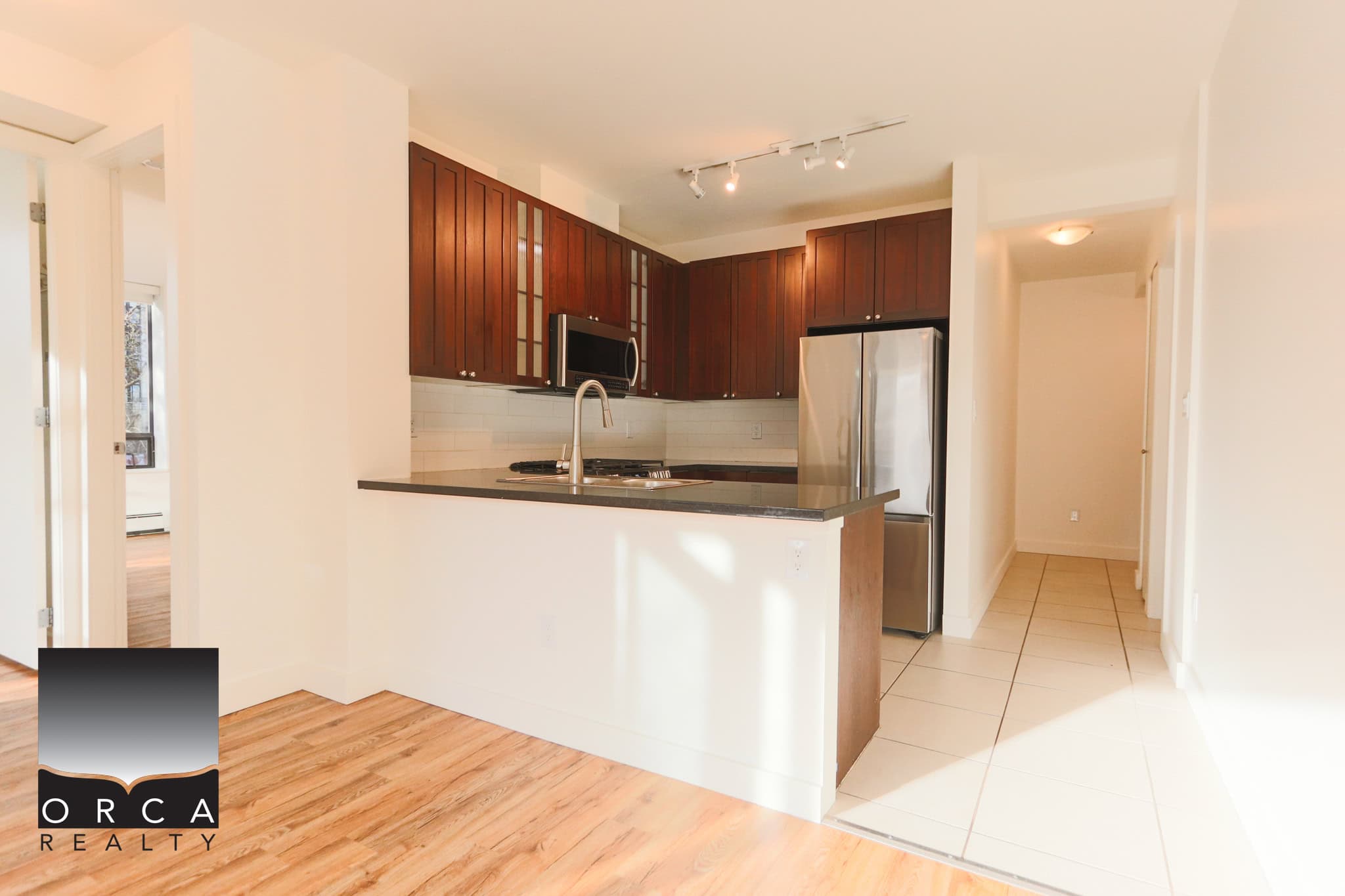 Bright, modern kitchen in North Vancouver with stainless steel appliances and dark wood cabinets. Perfect for contemporary living and entertaining.