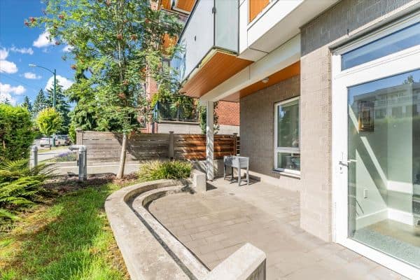 Bright and inviting outdoor patio area of a Vancouver townhouse at 101-7878 Granville Street, showcasing contemporary architecture and landscaped greenery.
