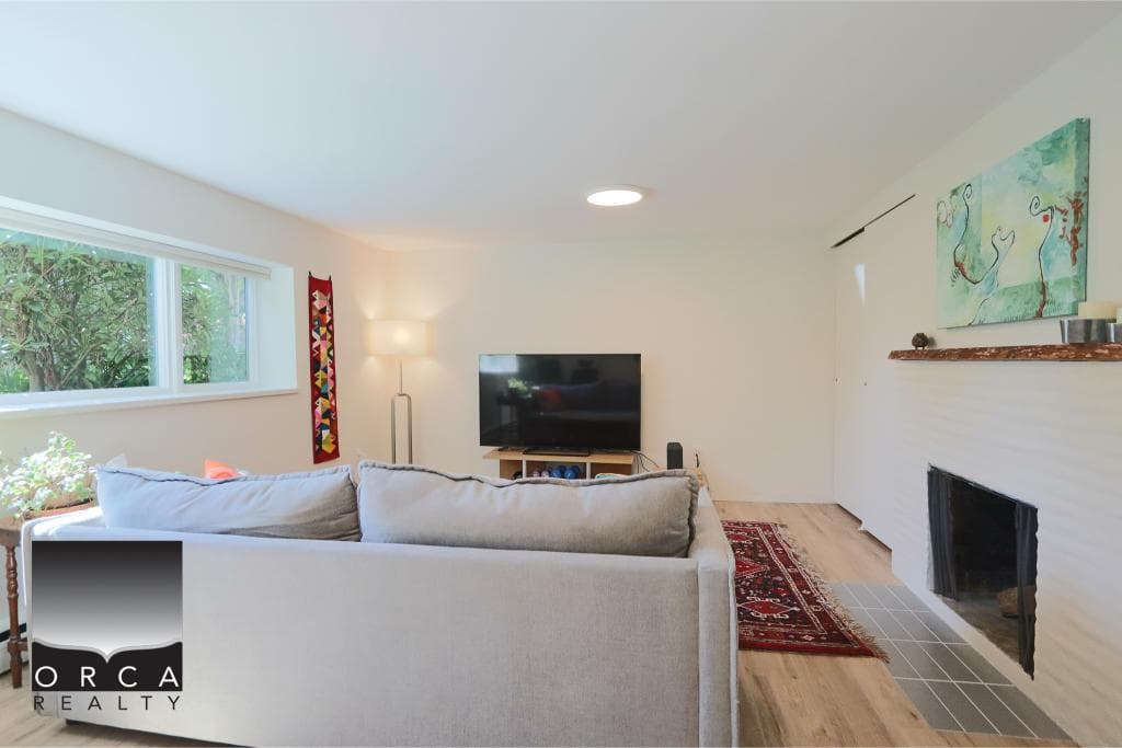 Bright living room in a Vancouver home with a cozy fireplace and modern decor, perfect for families or entertaining guests.