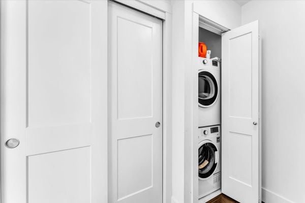 Efficient laundry space featuring stacked washer and dryer units inside a white closet in Vancouver, BC. Perfect for small homes or condos, offering convenient laundry solutions in a sleek, organized.