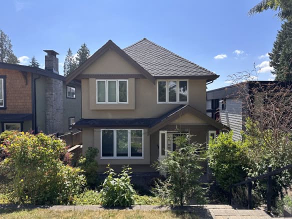 Modern two-story family home with beige exterior, large windows, and landscaped front yard in a friendly neighbourhood in Vancouver, BC. Perfect for families seeking comfort and style.