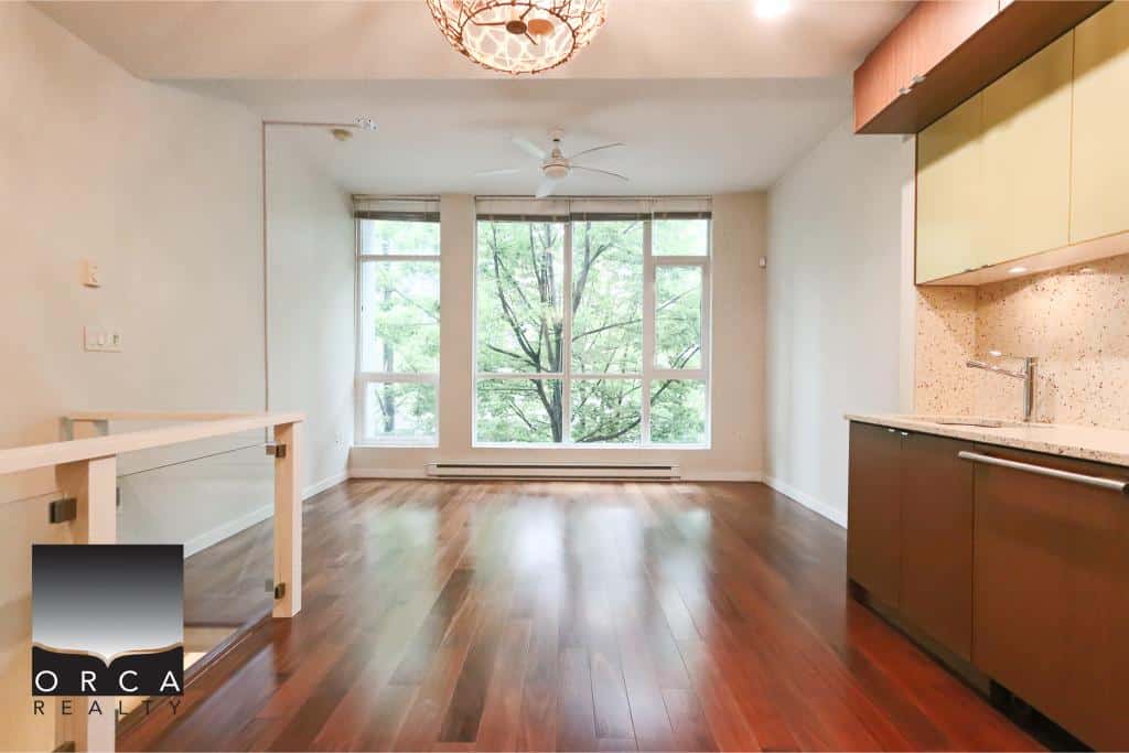 Bright modern condo interior with large windows and hardwood flooring, ideal for Vancouver real estate buyers seeking stylish Toronto apartments or homes.