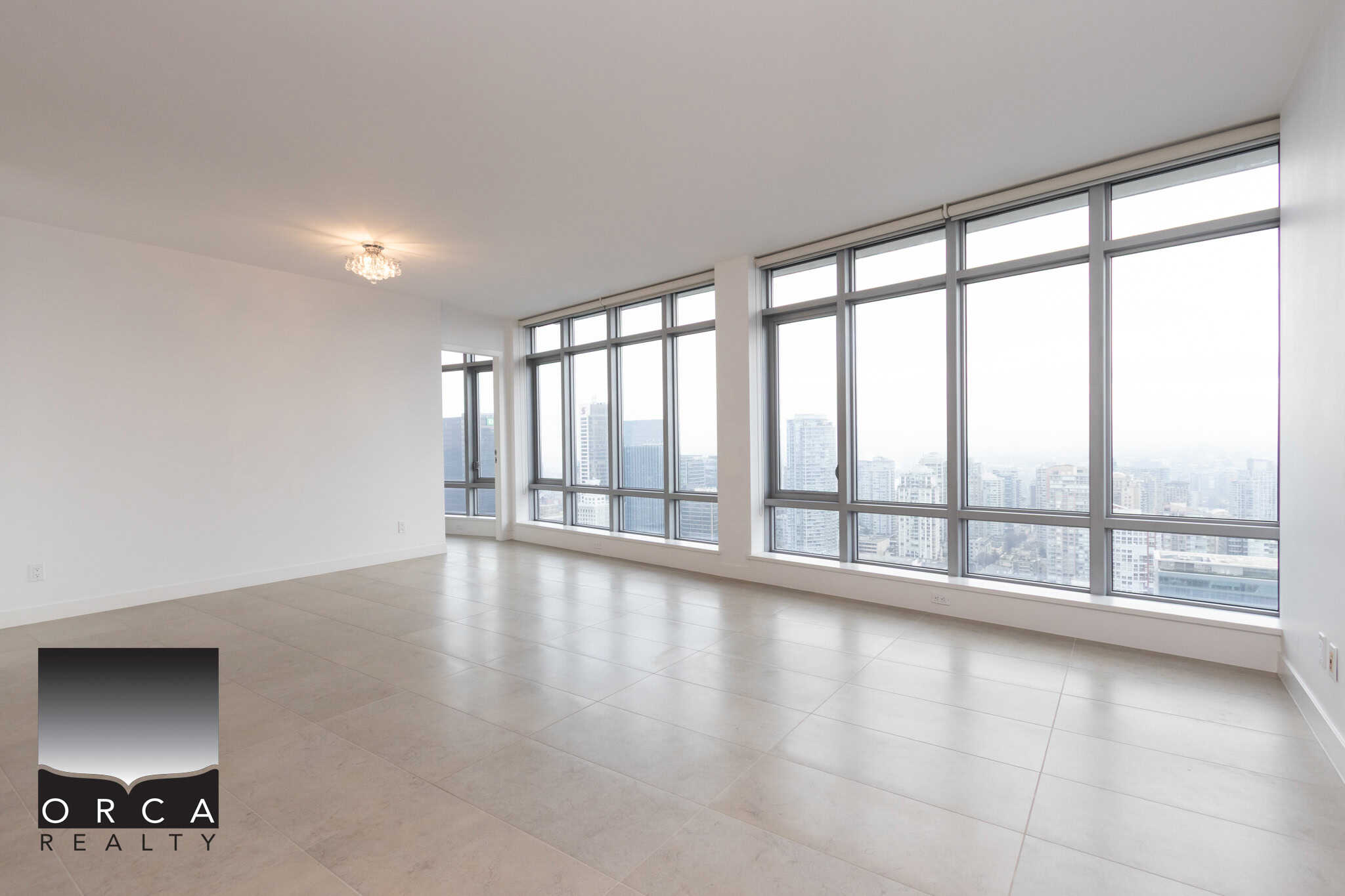 Bright urban condo with floor-to-ceiling windows, panoramic city views, spacious open living area, modern finishes, ideal for real estate investors or urban living enthusiasts in downtown Vancouver.
