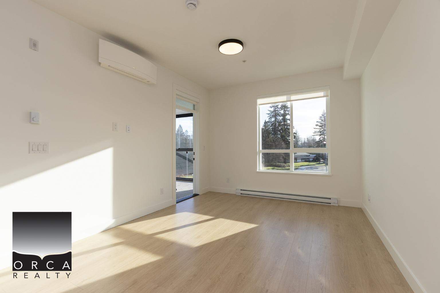 Bright, modern living space with large windows, white walls, and light wood flooring, perfect for Vancouver-area homes and real estate listings by Orca Realty Inc.