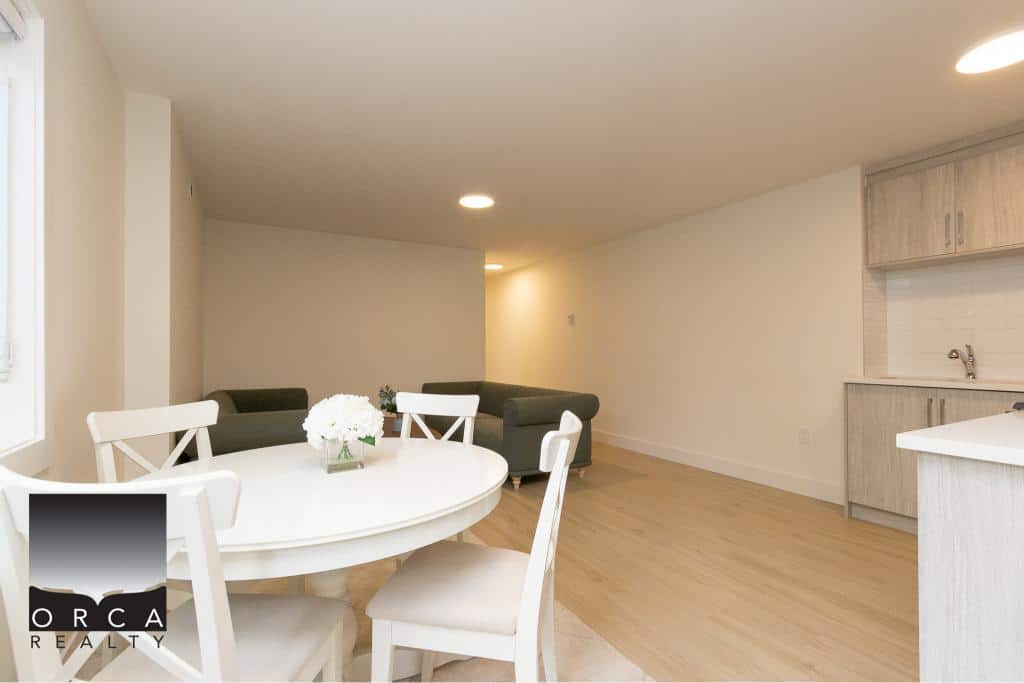 Bright and spacious living and dining area in a modern home, featuring neutral tones, ample natural light, and minimalist decor for a welcoming Vancouver-style residence.