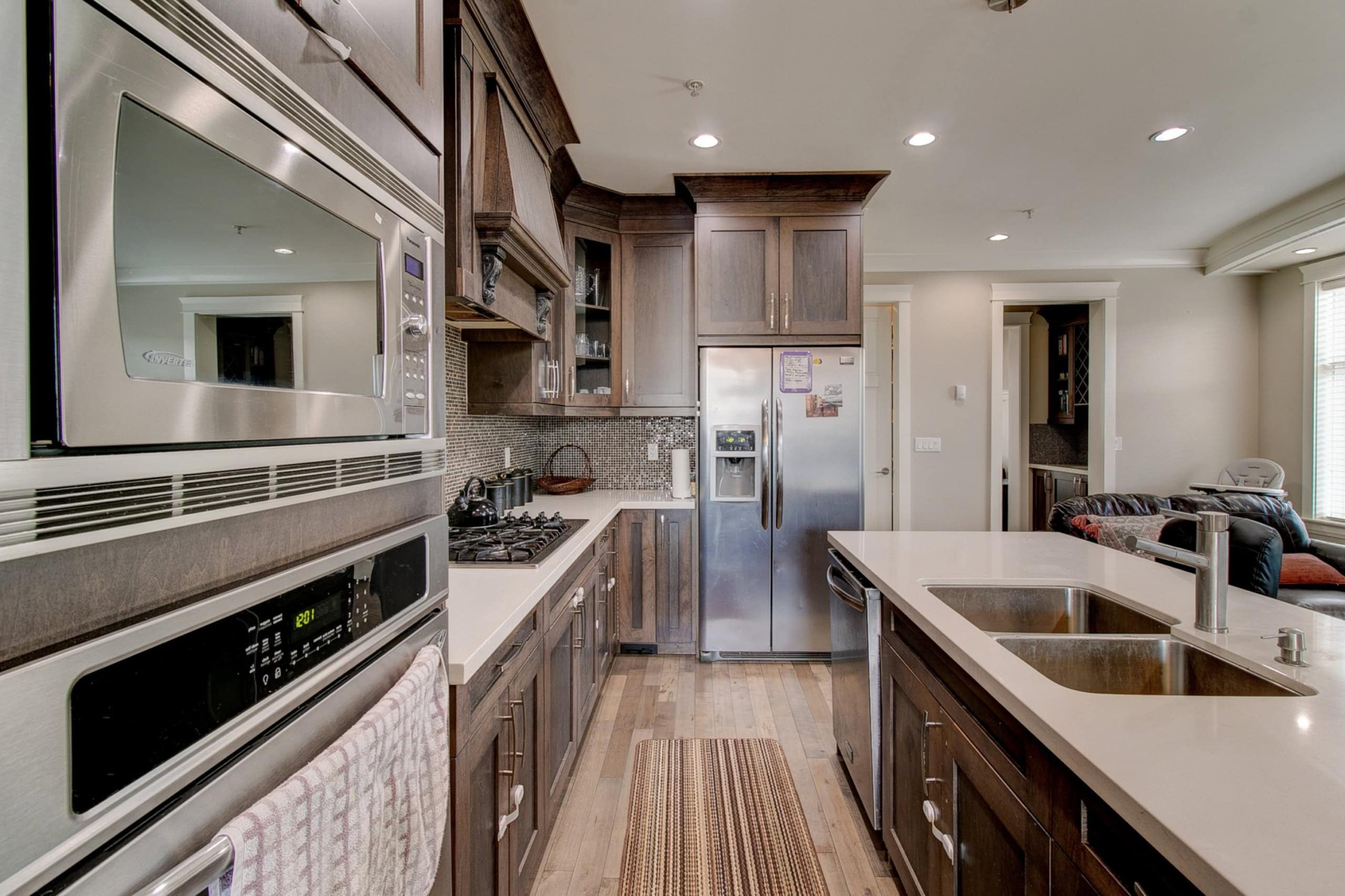 Spacious modern kitchen with dark wood cabinets, stainless steel appliances, and a large island for cooking and entertaining, perfect for Vancouver Island real estate buyers.