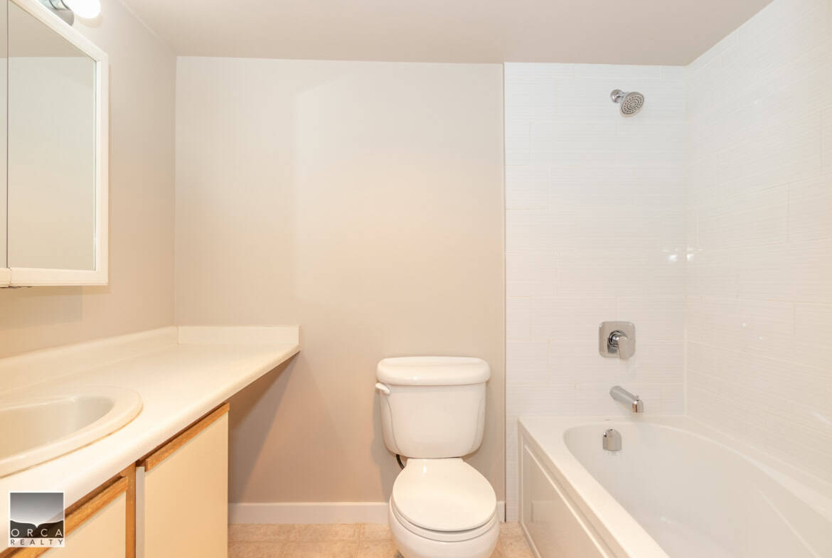 Clean white bathroom with bathtub, toilet, and vanity – ideal for Ontario real estate listings.
