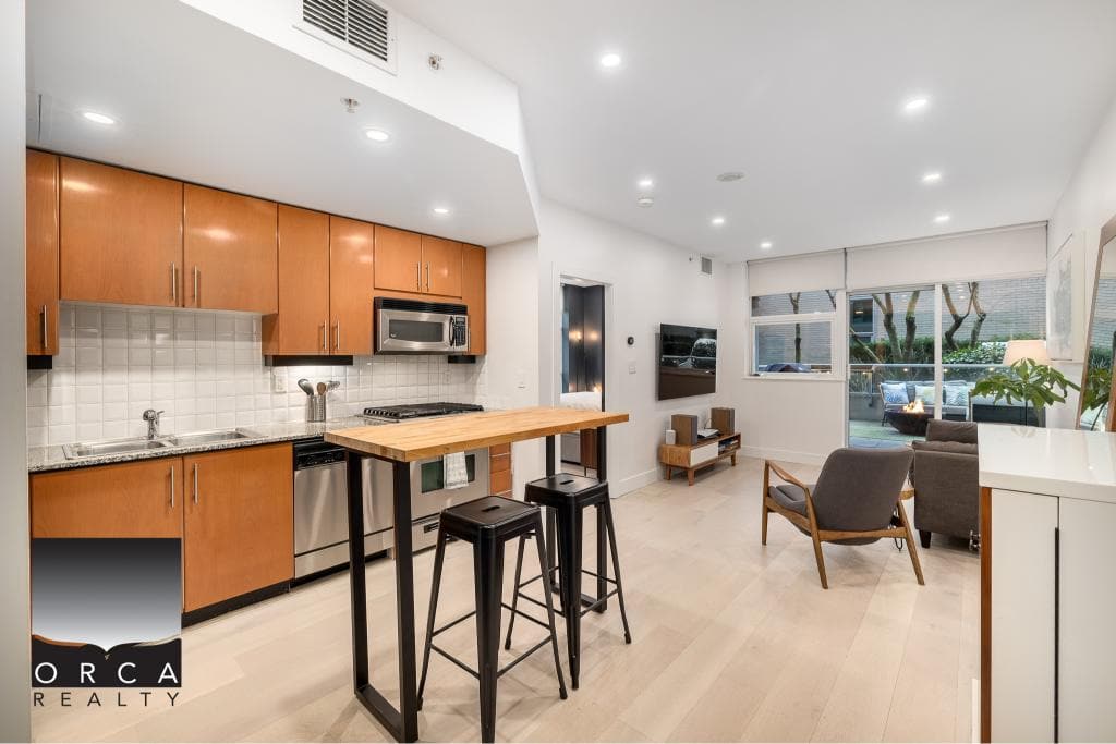 Bright modern Vancouver apartment kitchen and living room with natural light, sleek cabinetry, and stylish furnishings. Perfect for real estate listings and showcasing urban Vancouver homes.