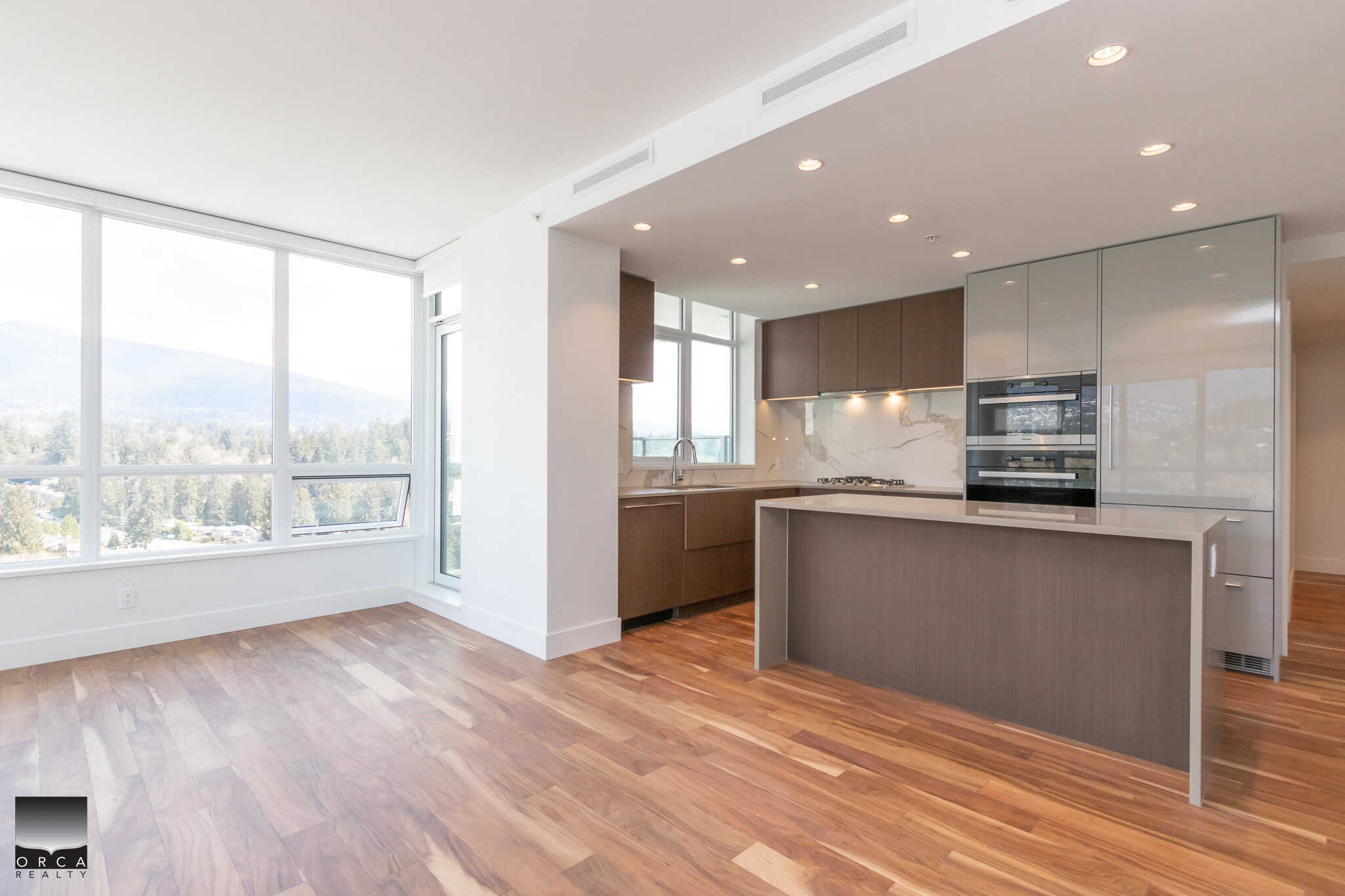 Stunning modern kitchen with large windows and hardwood floors in a premium Vancouver residence, showcasing luxury real estate and contemporary design by Orca Realty Inc.
