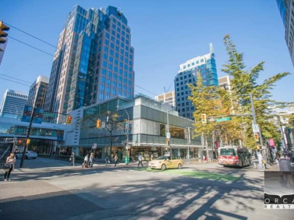 Modern downtown Vancouver cityscape featuring high-rise office buildings and bustling pedestrian traffic, ideal for real estate and commercial property investment.