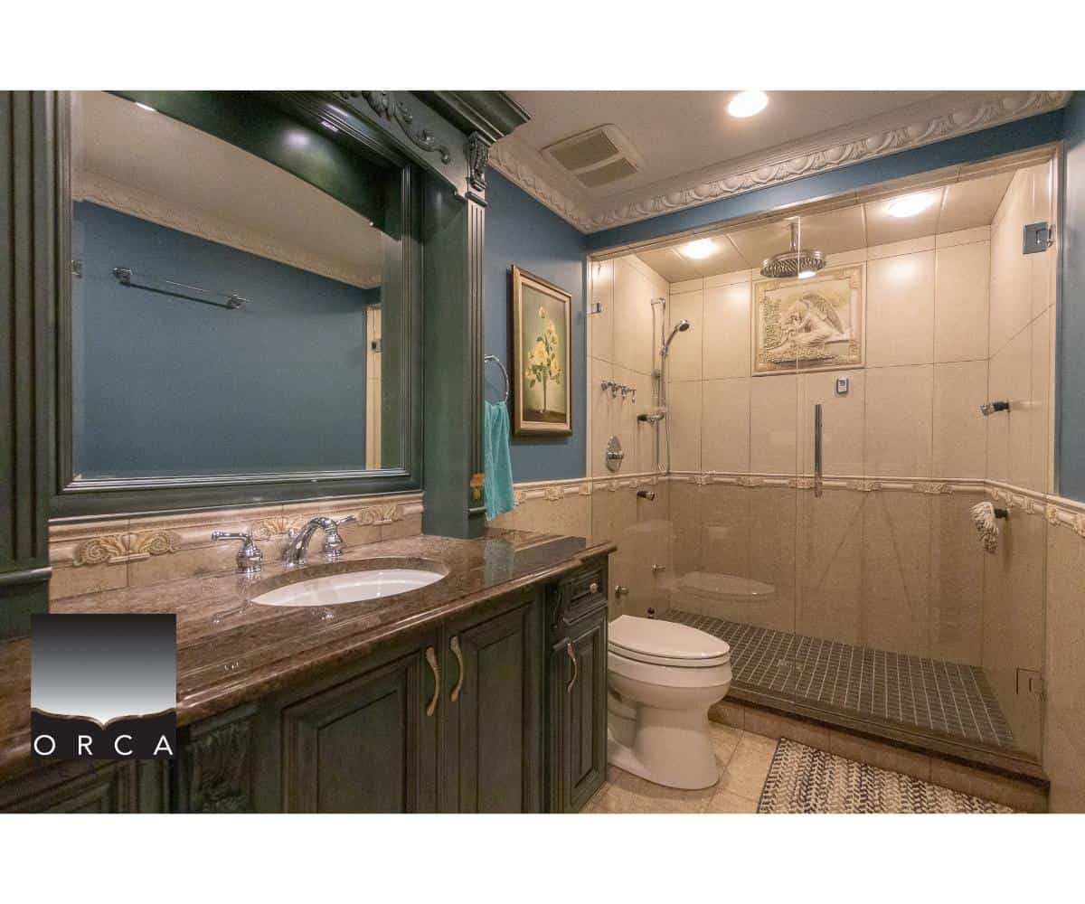Luxurious master bathroom with walk-in shower, elegant cabinetry, marble countertop, and decorative crown molding, showcasing premium real estate features in Vancouver.