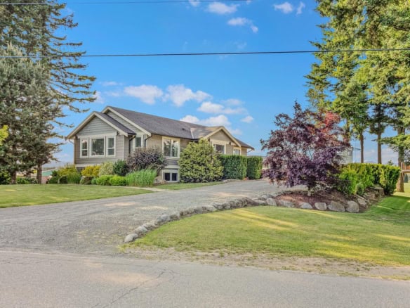 Lush landscaped front yard and spacious driveway of a modern family home in a serene neighbourhood in Vancouver.