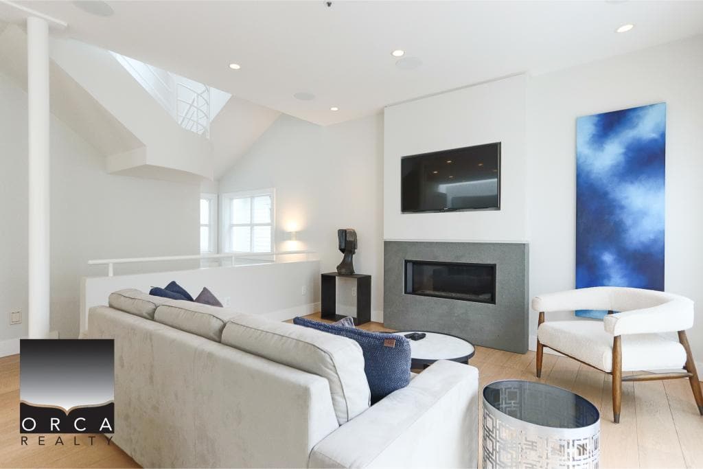 Bright modern living room with a sleek fireplace, flat-screen TV, and contemporary furniture in a spacious, well-lit interior designed for luxury real estate in Vancouver.